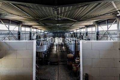 Bâtiment moderne éclairé la nuit, entouré d'un espace extérieur sombre avec un ciel nuageux en arrière-plan.