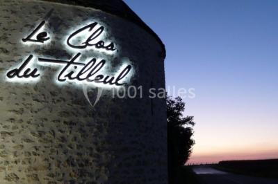 Miniature Location salle Roches (Loir-et-Cher) - Le Clos du Tilleul #24 Mur en pierre avec une enseigne lumineuse ’Le Clos du Tilleul’, route et ciel au crépuscule en arrière-plan.