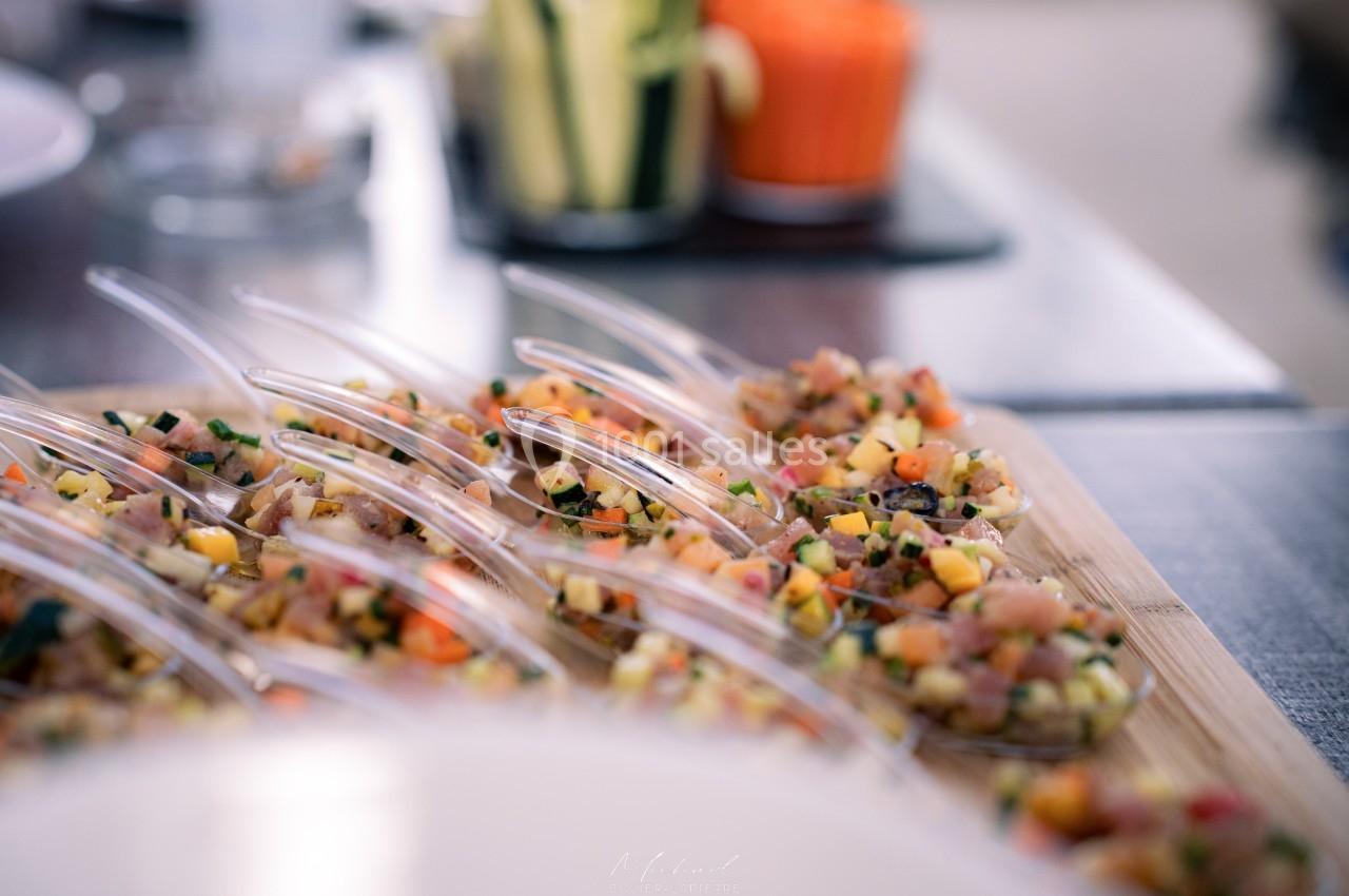 Cuillères apéritives garnies de tartare de légumes et fruits frais, présentées sur un plateau en bois.