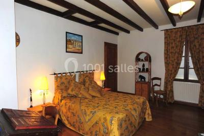 Salle de réception décorée avec des tables dressées, nappes blanches et éclairage chaleureux.