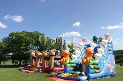 Salle de réception décorée avec des tables dressées, nappes blanches et éclairage chaleureux.