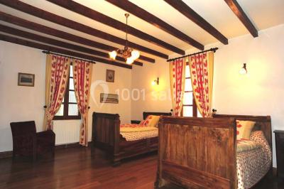 Salle de réception décorée avec des tables dressées, nappes blanches et éclairage chaleureux.