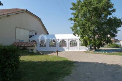 Salle de réception décorée avec des tables dressées, nappes blanches et éclairage chaleureux.