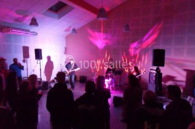 Des personnes assises et debout discutent dans une salle conviviale avec des tables, des chaises et des décorations murales.