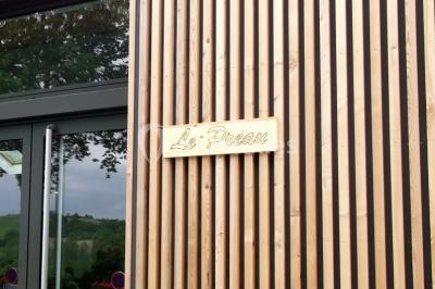 Des personnes assises et debout discutent dans une salle conviviale avec des tables, des chaises et des décorations murales.