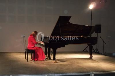 Des personnes assises et debout discutent dans une salle conviviale avec des tables, des chaises et des décorations murales.