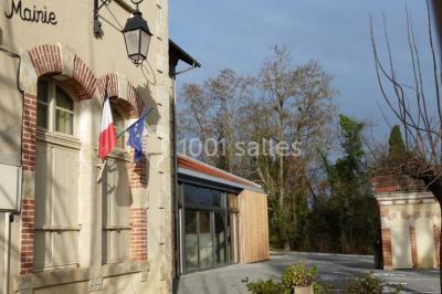 Des personnes assises et debout discutent dans une salle conviviale avec des tables, des chaises et des décorations murales.