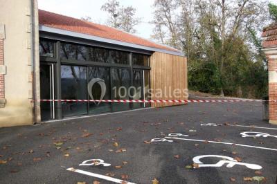 Des personnes assises et debout discutent dans une salle conviviale avec des tables, des chaises et des décorations murales.