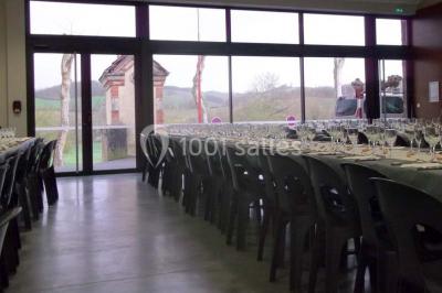 Des personnes assises et debout discutent dans une salle conviviale avec des tables, des chaises et des décorations murales.