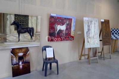 Des personnes assises et debout discutent dans une salle conviviale avec des tables, des chaises et des décorations murales.