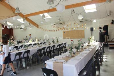 Des personnes assises et debout discutent dans une salle conviviale avec des tables, des chaises et des décorations murales.