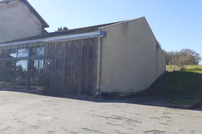 Des personnes assises et debout discutent dans une salle conviviale avec des tables, des chaises et des décorations murales.