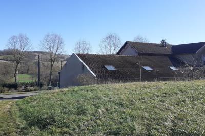 Des personnes assises et debout discutent dans une salle conviviale avec des tables, des chaises et des décorations murales.