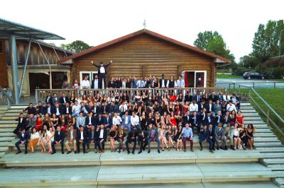 Bassin artificiel entouré de palmiers et de rochers, avec un paysage verdoyant en arrière-plan.