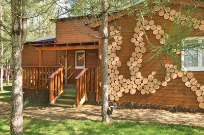 Bassin artificiel entouré de palmiers et de rochers, avec un paysage verdoyant en arrière-plan.