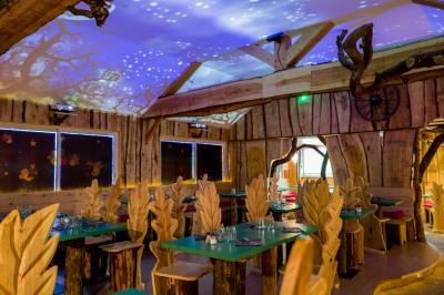 Bassin artificiel entouré de palmiers et de rochers, avec un paysage verdoyant en arrière-plan.