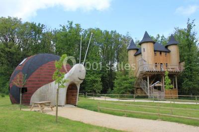 Bassin artificiel entouré de palmiers et de rochers, avec un paysage verdoyant en arrière-plan.