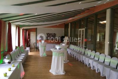 Bassin artificiel entouré de palmiers et de rochers, avec un paysage verdoyant en arrière-plan.