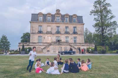 Vue d'une salle de bain avec double vasque en bois et d'une chambre lumineuse avec parquet et grandes fenêtres.