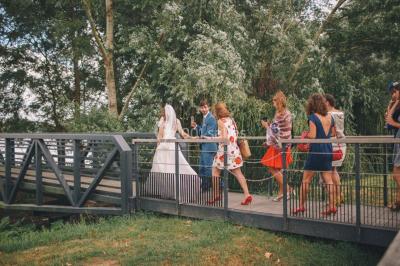Vue d'une salle de bain avec double vasque en bois et d'une chambre lumineuse avec parquet et grandes fenêtres.