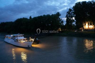 Vue d'une salle de bain avec double vasque en bois et d'une chambre lumineuse avec parquet et grandes fenêtres.