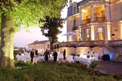 Vue d'une salle de bain avec double vasque en bois et d'une chambre lumineuse avec parquet et grandes fenêtres.