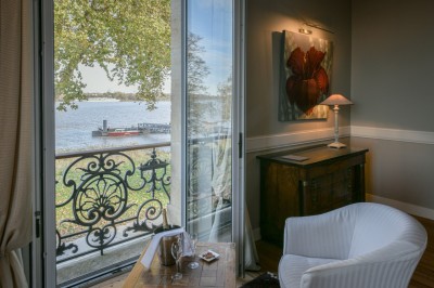 Salle de réception décorée avec des tables rondes, nappes blanches, chandeliers et arrangements floraux élégants.