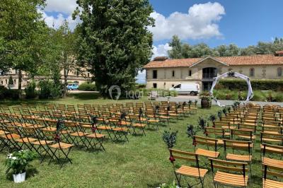 Vue d'une salle de bain avec double vasque en bois et d'une chambre lumineuse avec parquet et grandes fenêtres.