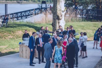 Vue d'une salle de bain avec double vasque en bois et d'une chambre lumineuse avec parquet et grandes fenêtres.
