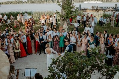 Vue d'une salle de bain avec double vasque en bois et d'une chambre lumineuse avec parquet et grandes fenêtres.