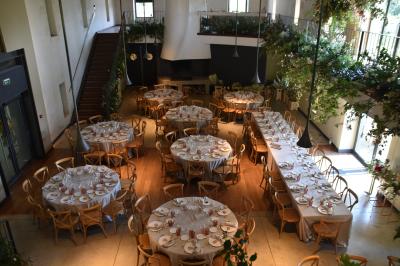 Vue d'une salle de bain avec double vasque en bois et d'une chambre lumineuse avec parquet et grandes fenêtres.