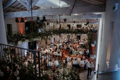Vue d'une salle de bain avec double vasque en bois et d'une chambre lumineuse avec parquet et grandes fenêtres.