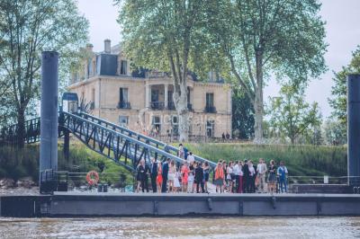 Vue d'une salle de bain avec double vasque en bois et d'une chambre lumineuse avec parquet et grandes fenêtres.