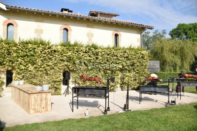 Vue d'une salle de bain avec double vasque en bois et d'une chambre lumineuse avec parquet et grandes fenêtres.