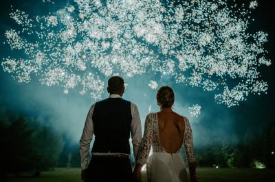 Vue d'une salle de bain avec double vasque en bois et d'une chambre lumineuse avec parquet et grandes fenêtres.
