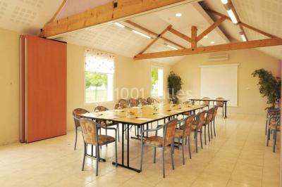 Buffet de petit-déjeuner avec viennoiseries, fruits, céréales et boissons, présenté dans une salle lumineuse.