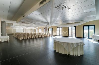 Buffet de petit-déjeuner avec viennoiseries, fruits, céréales et boissons, présenté dans une salle lumineuse.