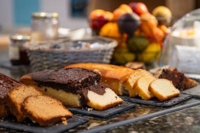 Buffet de petit-déjeuner avec viennoiseries, fruits, céréales et boissons, présenté dans une salle lumineuse.