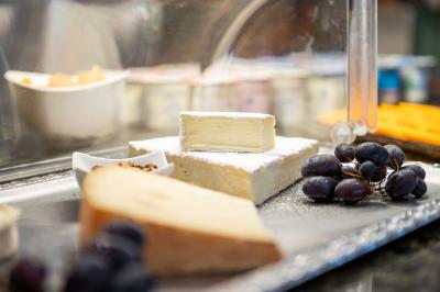 Buffet de petit-déjeuner avec viennoiseries, fruits, céréales et boissons, présenté dans une salle lumineuse.