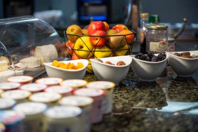 Buffet de petit-déjeuner avec viennoiseries, fruits, céréales et boissons, présenté dans une salle lumineuse.