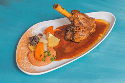 Buffet de petit-déjeuner avec viennoiseries, fruits, céréales et boissons, présenté dans une salle lumineuse.