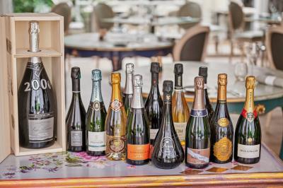 Buffet de petit-déjeuner avec viennoiseries, fruits, céréales et boissons, présenté dans une salle lumineuse.