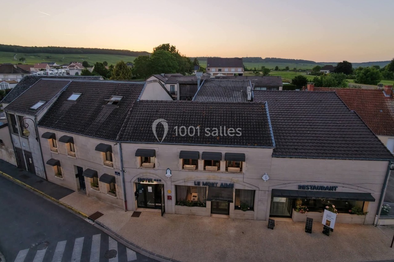 Façade d'un bâtiment en pierre avec un restaurant, vue au crépuscule dans un village rural.