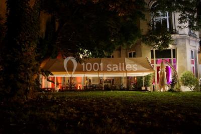 Assiette de noix de Saint-Jacques poêlées, accompagnées de légumes, agrumes et herbes fraîches sur un fond flou.