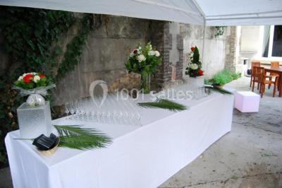Assiette de noix de Saint-Jacques poêlées, accompagnées de légumes, agrumes et herbes fraîches sur un fond flou.