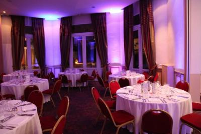Assiette de noix de Saint-Jacques poêlées, accompagnées de légumes, agrumes et herbes fraîches sur un fond flou.