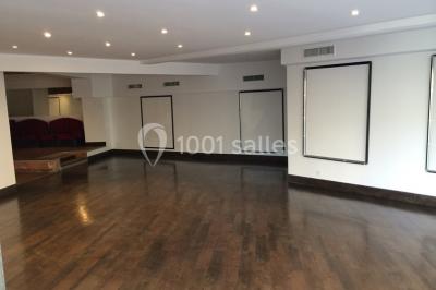 Façade d'un cinéma jaune avec plusieurs affiches de films, situé dans une rue ensoleillée.