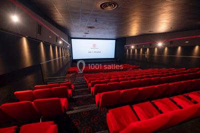 Vue extérieure d'un complexe IMAX moderne avec une esplanade dégagée et un ciel partiellement nuageux.