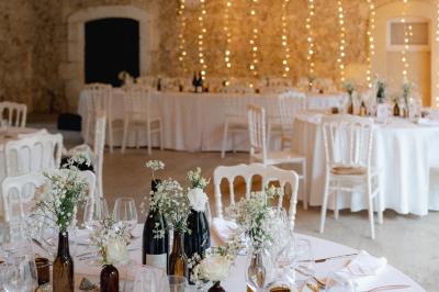 Structure en fer forgé dans un jardin, avec des invités rassemblés en arrière-plan près d'un arbre.