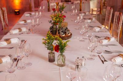 Structure en fer forgé dans un jardin, avec des invités rassemblés en arrière-plan près d'un arbre.